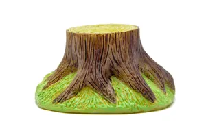 Vue détaillée de la figurine miniature de souche d'arbre avec base en herbe verte.