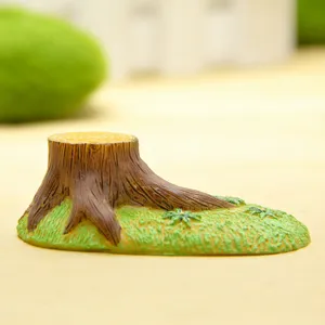 Miniature figurine de souche d'arbre avec base en herbe verte pour micro-paysage et déco.