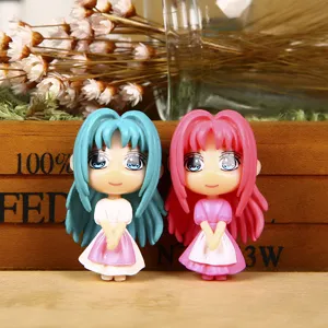 Cute anime cartoon girl keychain detail shot, miniature pendant figures with blue and pink hair.