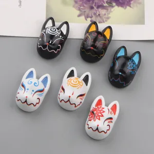 Detailed view of resin Japanese kitsune fox mask fridge magnets and phone case charms.