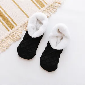 Primo piano di comode calze da interno in pile nero e bianco per il calore invernale accogliente.