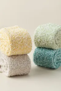 Détail de chaussettes duveteuses en polaire corail douce avec texture roulée colorée.