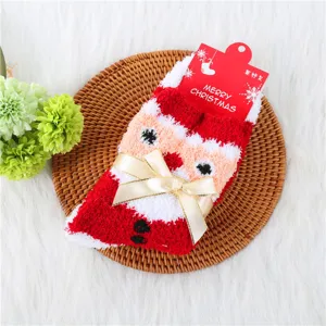 Cozy Christmas fuzzy socks for women with cute Santa Claus design and elegant golden ribbon bow.