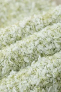 Gros plan sur un tissu polaire corail moelleux, fil texturé doux pour chaussettes confortables.