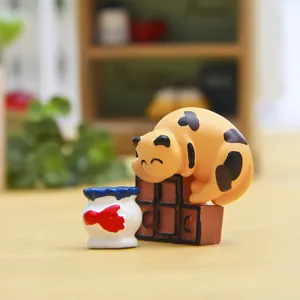 Detailaufnahme einer süßen dicken Katzenfigur, die auf einem Minischrank schläft.