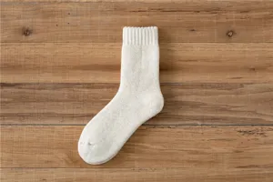 Detailaufnahme von verdickten Wollstrick-Wintersocken in Off-White, kuschelige Textur.