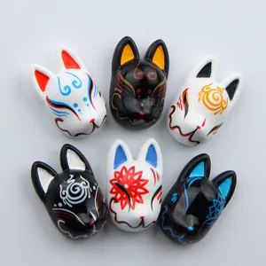 Close-up detail of cute 3D Japanese fox mask resin fridge magnets with traditional painted patterns.