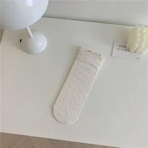Dettaglio calzini a tubo medio in pizzo bianco, stile Lolita carino per outfit dolci.