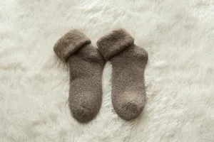 Detailed view of cozy winter thick thermal wool socks in brown color, fluffy snow style.