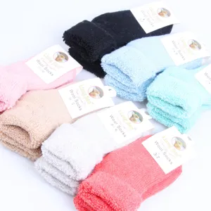 Gedetailleerd shot van gezellige kinderwollen sokken met omgeslagen boorden in diverse kleuren.