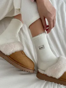 Nahaufnahme von dicken Damen Thermostrickwintersocken mit Plüschfutter und Hausschuhen.
