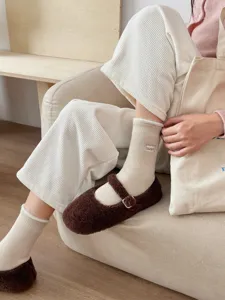 Gemütliche thermische Damen-Fleece-Socken im Mitteltubus-Detail in gemütlicher Wohnzimmerumgebung.