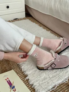 Gemütliche rosa flauschige gefütterte Wadensocken Winter Thermosocken Detail im warmen Zimmer.