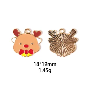 Gros plan sur le pendentif en alliage de renne de Noël, finition métal doré brillant et émail coloré.