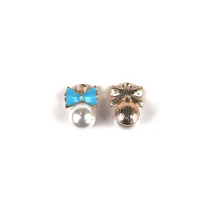Detail shot of DIY alloy bowknot and white pearl pendant charms for handmade jewelry making.