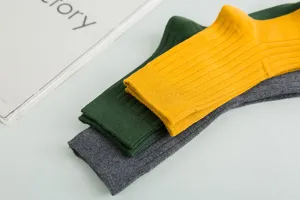 Vue détaillée de chaussettes montantes en coton côtelé pour homme en jaune, vert et gris.