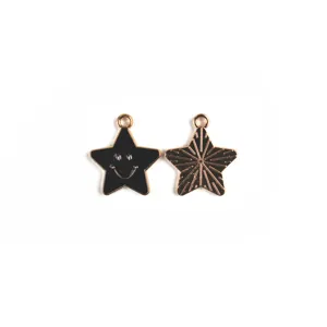 Pendentifs etoile en alliage noir et dore avec smiley et rayons pour la creation de bijoux.