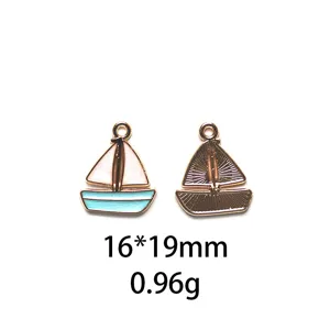 Detailopname van de geëmailleerde zeilbootbedel met gekleurde voorkant en getextureerde achterkant.