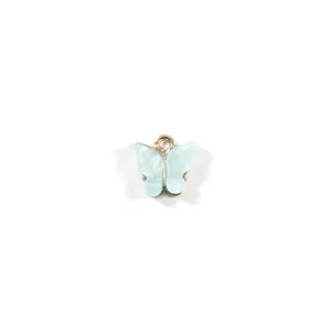 Gros plan détail du pendentif charme papillon en résine bleu clair avec anneau métallique.