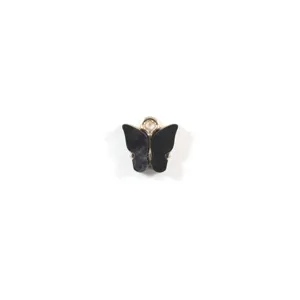 Gros plan d'un pendentif papillon en résine noire, montrant des bords lisses et brillants.