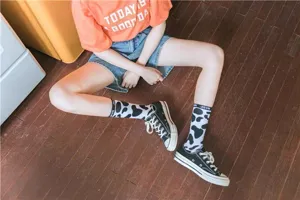 Cute black and white cow print mid-calf socks for women, Korean Harajuku style hosiery.