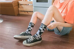 Close-up of black and white cow print mid-tube socks, stylish Harajuku streetwear details.