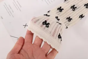 Close-up detail shot of sheer mesh knit women's mid-tube socks featuring black bows.