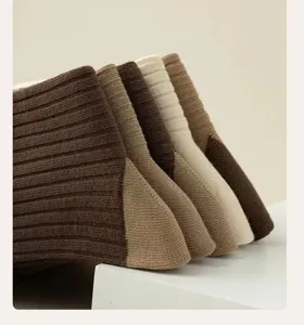 Brown striped mid-calf socks for women, retro aesthetic warm winter knit hosiery style.
