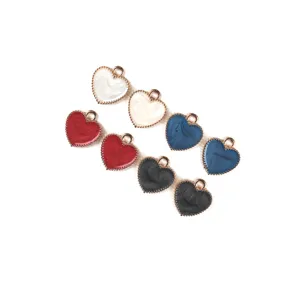 Close-up of marbled enamel heart charms with beaded edge and jump ring for DIY jewelry.