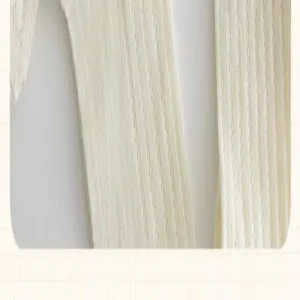Close-up of white ribbed knit socks, showcasing fine texture and elastic fabric material.