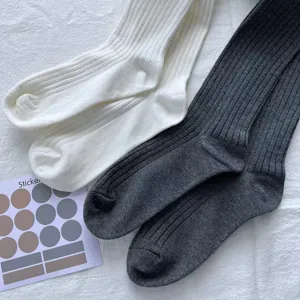 Calzini a coste in maglia bianca e grigio scuro, misto cotone morbido, dettaglio in stile minimal.