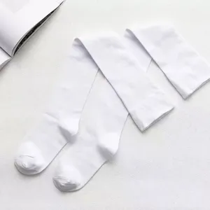 Detail view of white over-the-knee socks flat lay on textured surface for comfort.