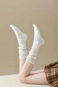 Detail shot of white ribbed slouch socks, soft knit texture, casual daily wear style.