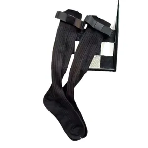 Calze alte nere a costine con elegante fiocco, indumento da gamba comodo e alla moda.