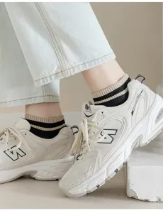 Close-up detail of striped ankle socks paired with retro sports sneakers, breathable and stylish.