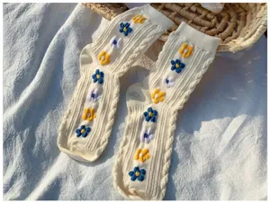 Close-up of cute floral embroidered knit mid-calf socks in cream white, detail shot.