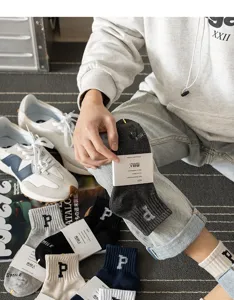 Detailed shot of sports short socks with letter embroidery and paper tags in a lifestyle scene.