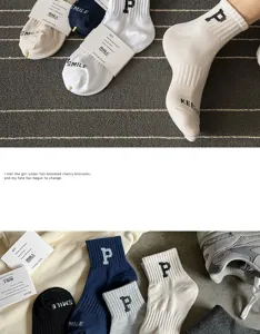 Close-up detail of stylish cotton crew socks featuring embroidered letter P and smile text.