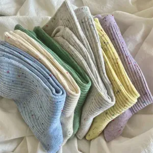 Detailed close up of soft cotton slouch socks in colorful pastel shades on white cloth