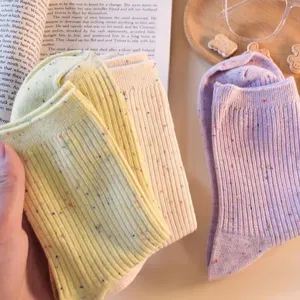 Close-up detail of colorful flecked knit mid-tube socks, soft cotton texture lifestyle display