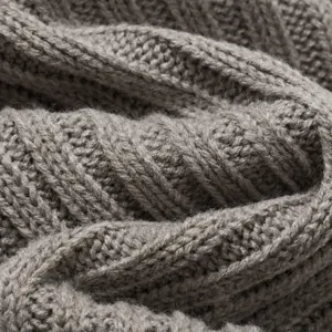 Close-up detail of grey knit leg warmers fabric texture, soft and warm winter accessory.