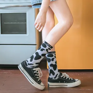 Detailed shot of Japanese style black and white cow print mid-calf socks for women.