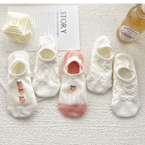 Vue détaillée de chaussettes basses blanches d'été pour femmes avec tricot fin et broderie de pêche.