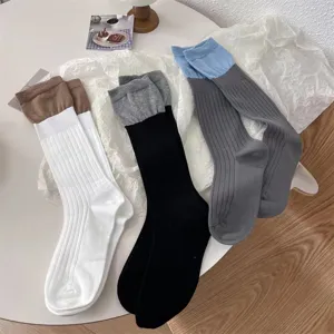 Vue détaillée de chaussettes élégantes pour femmes bicolores avec de beaux bords côtelés.
