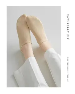 Close-up of minimalist beige low-cut socks worn with white trousers, clean aesthetic.