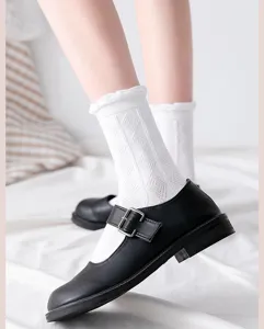 Close-up detail of white lace mid-tube socks paired with black shoes, breathable cotton style.