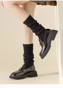 Knit leg warmers detail shot, pairing with black loafers and skirt for a stylish look.