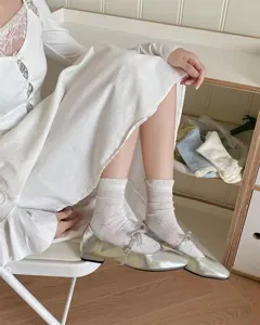 Primer plano de calcetines blancos transparentes con lazos delicados y puños suaves y finos.