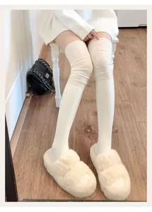 Detail view of solid color ribbed over-the-knee socks for women, cozy winter long leg wear.