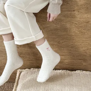 Close-up detail of cozy plush winter socks featuring soft mink fleece and cute bow embroidery.